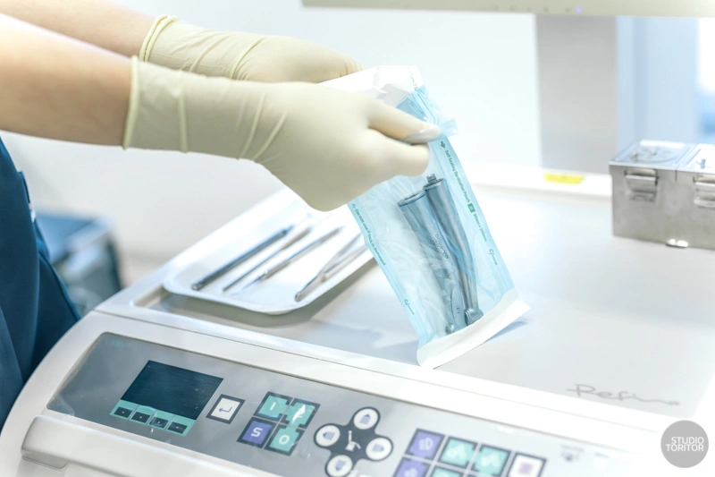 患者ごとに高圧蒸気滅菌されたパック入り医療器具を開封する衛生管理の様子