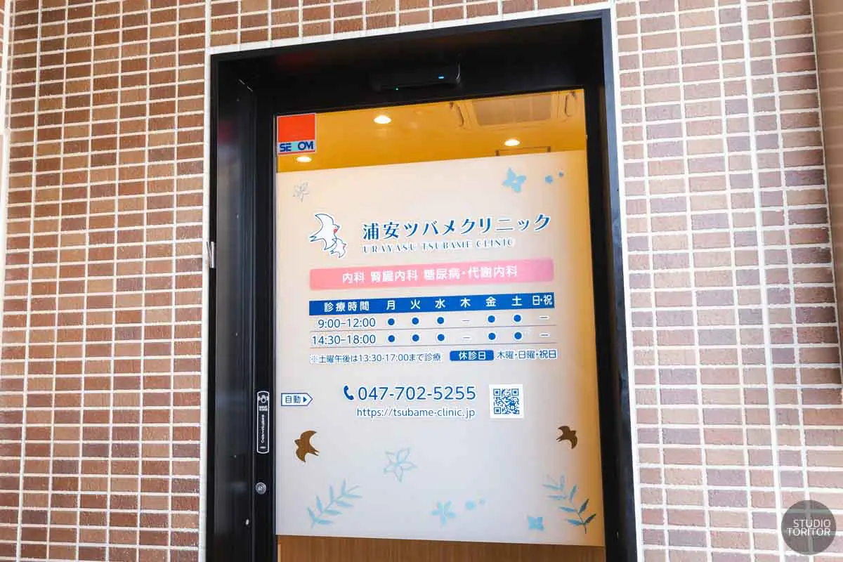 診療時間が明記されたクリニックの自動ドアエントランス外観。写真撮影事例。