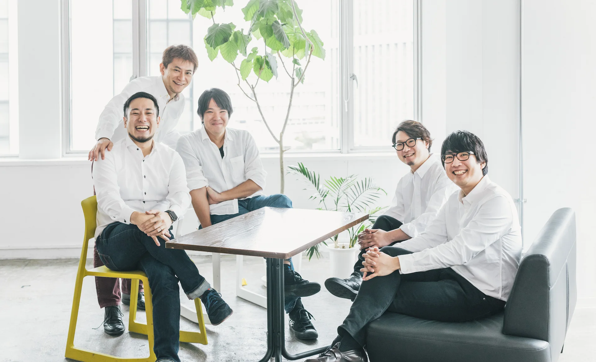 プロカメラマンによる企業・法人向けのカジュアルな採用写真撮影の実績（5人のスタッフ談笑シーンメインビジュアル）
